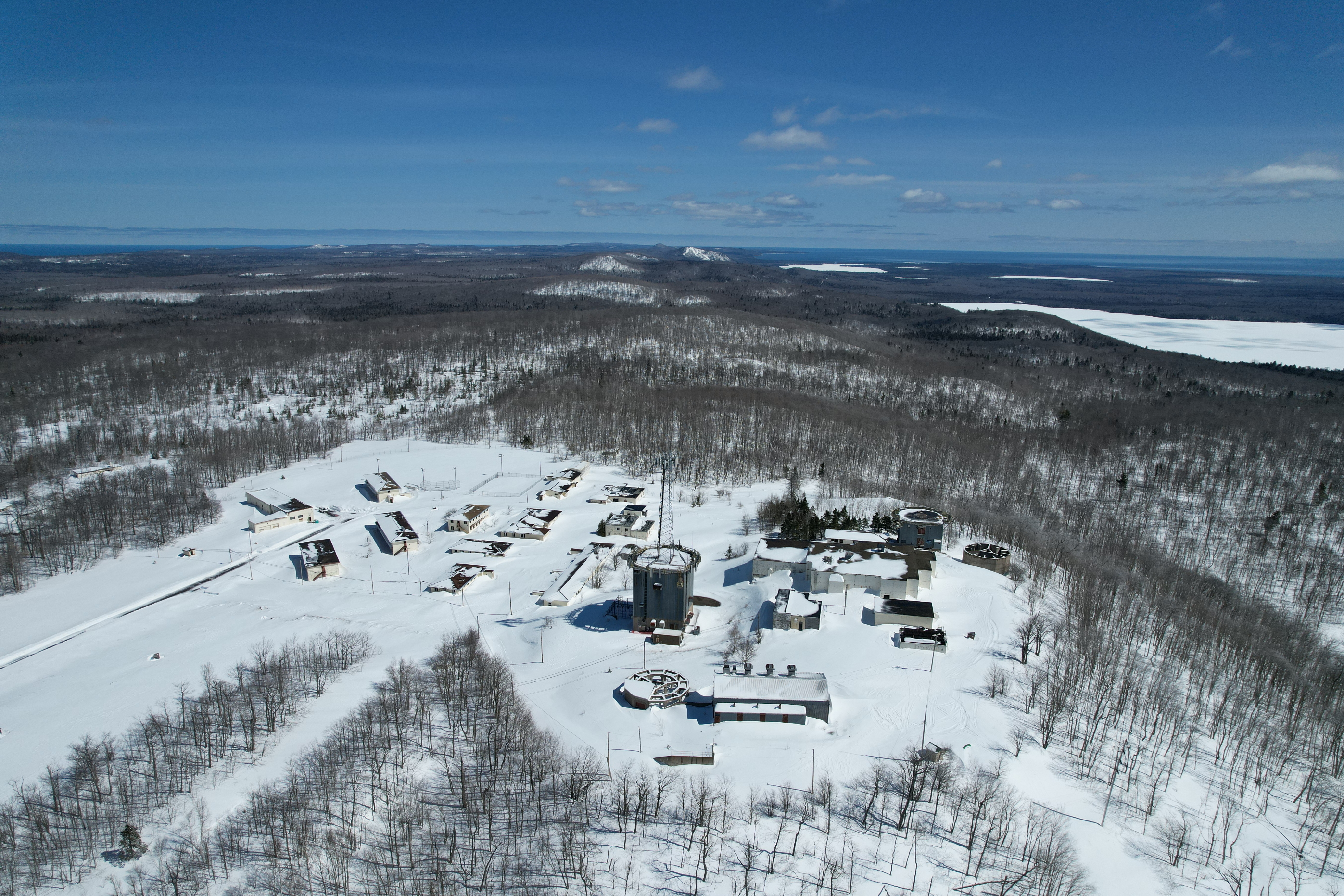 A drone image of Calumet Air Force Station in winter on top of Mount Horace Greeley.